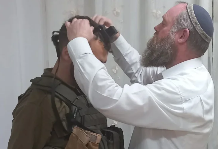 הרב עמיחי איל מסייע לחייל להניח תפילין, מתוך הכתבה בהידברות